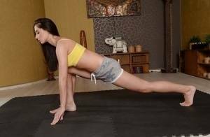 Cute brunette babe Aruna Aghora doing yoga in shorts and bare feet on fanspics.com