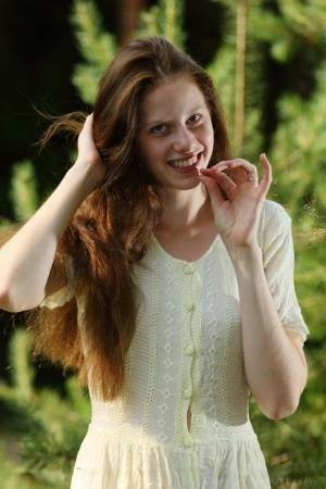 Pale girl with long red hair Nicole K gets totally naked amid saplings on fanspics.com