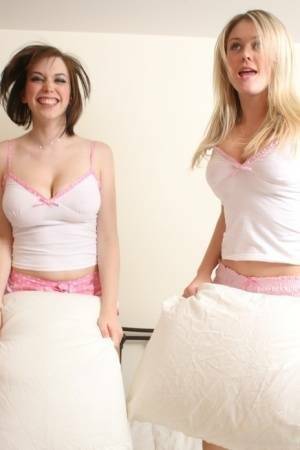 Young blonde Brooke Little and a girlfriend expose their big naturals on a bed on fanspics.com