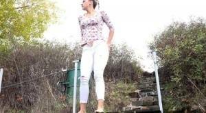 Mature Bianca pulls down her white pants to take a steaming pee outside on fanspics.com