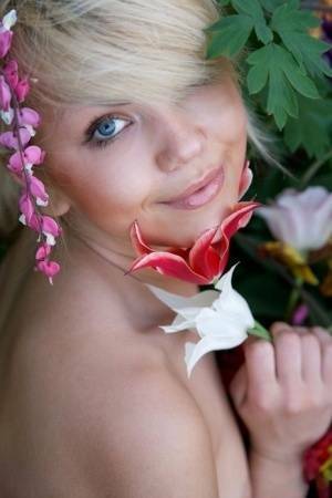 Cute young blonde Iveta poses in the nude while in a garden on fanspics.com