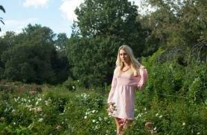 Dirty blonde Dolly touches her hairy teen pussy with a white rose on a lawn on fanspics.com