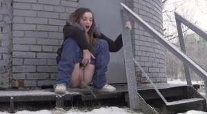 White girl pulls down her jeans to pee in the snow behind a building on fanspics.com