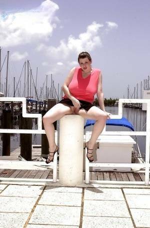 Plump pornstar Desirae flashing her huge tits and upskirt pussy on boat dock on fanspics.com