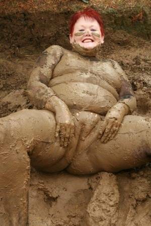 Older redhead Valgasmic Exposed rolls around in a mud pit while totally naked on fanspics.com