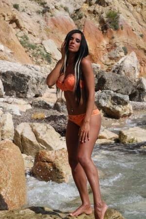 Leggy teen with long hair takes off her bikini in a fast moving stream on fanspics.com
