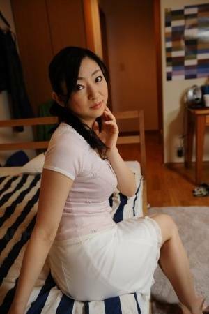 Slender mature Japanese woman Emiko Koike bends over to pose in white dress - Japan on fanspics.com