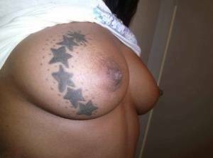 Ebony amateur takes self shots of her big tattooed boobs and bald vagina on fanspics.com