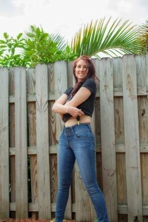 Hot redhead Andy Adams loses her t-shirt & jeans in the yard to pose naked on fanspics.com