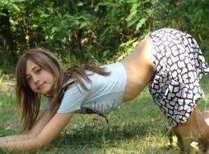 Shapely young teen in tiny t-shirt and short skirt posing outdoors on fanspics.com