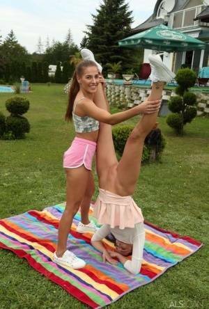 Young lesbians Eveline Dellai & Katy Rose fist pussies during sex on a lawn on fanspics.com