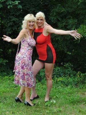 Mature lesbian Dimonty and GF cover their naked bodies in see thru raincoats on fanspics.com