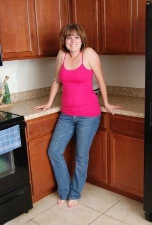 Redhead amateur Misty B gets completely naked in her kitchen on fanspics.com