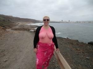 Aged lady Barby looses her big tits from a crotchless bodystocking by the sea on fanspics.com