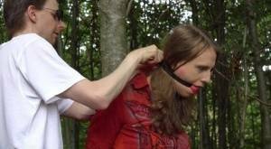 Clothed girl in canvas sneakers finds herself handcuffed to a tree in woods on fanspics.com