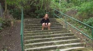 Natural redhead Chrissy Fox squats for a pee on a set of public steps on fanspics.com