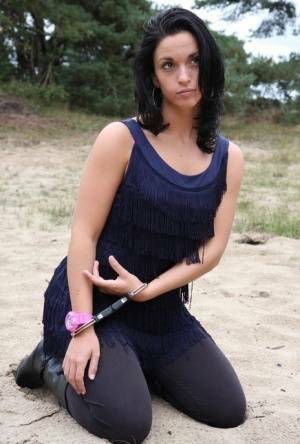 Brunette girl Nora is handcuffed to a tree while wearing a pink G-Shock watch on fanspics.com