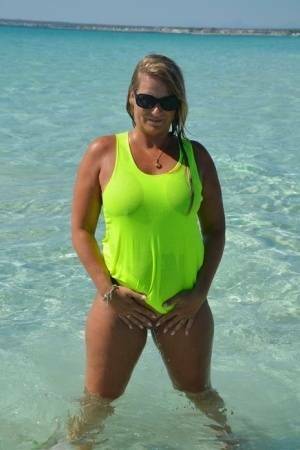 Middle-aged blonde Sweet Susi exposes her ass and pussy while in the ocean on fanspics.com