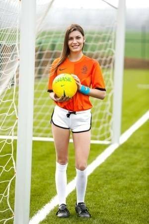 Lilly P is undressing her soccer uniform while on the field with a ball on fanspics.com