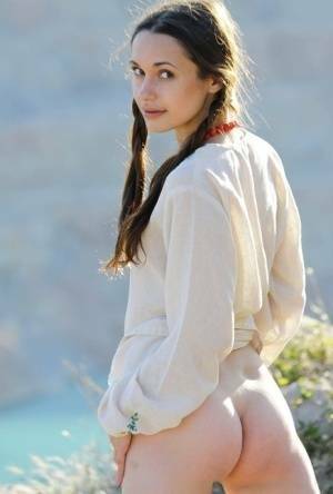 Teen model Ilona B poses nude in pigtails high above ocean waters on fanspics.com