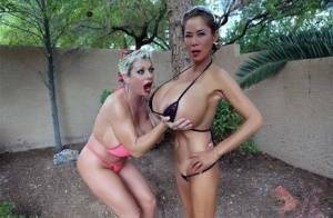 Big titted older women Claudia Marie and Minka kiss outdoors in skimpy bikinis on fanspics.com