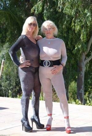 Mature blonde Melody and her lesbian lover bare their boobs on a building site on fanspics.com