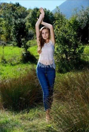 Natural beauty grabs her tight ass after getting naked in a field on fanspics.com