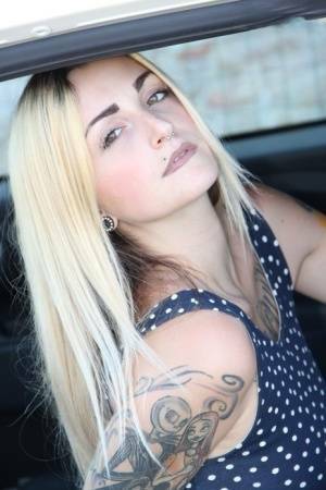 Tattooed girl Medusa Blonde shows her bare feet and ass while in a car on fanspics.com