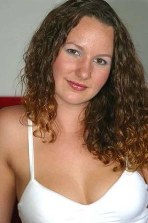 Amateur chick with wavy hair and a phat ass finger spreads her pussy on a sofa on fanspics.com