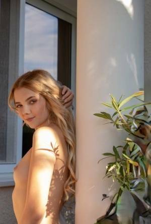 Young blonde Chanel Fenn shows her sexy ass while getting naked in a garden on fanspics.com