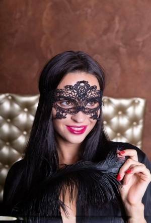 Sexy brunette Leyla Lee removes a mask and robes to pose nude with a feather on fanspics.com