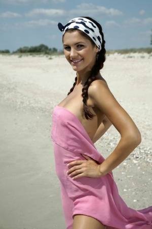 Teen solo girl Lola B strikes glamorous nude poses while at the beach on fanspics.com