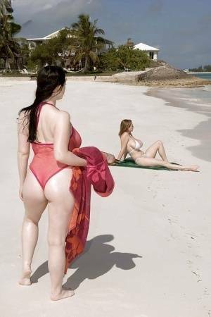 Fervent lesbians stripping nude and playing with dildos on the beach on fanspics.com