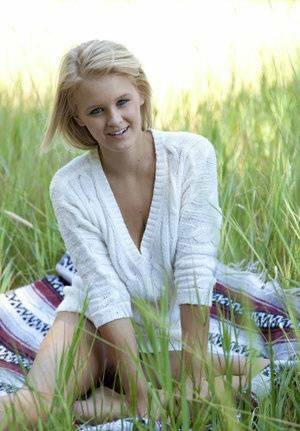 Blue eyed blonde teen Marie casts off her clothes to pose nude in a field on fanspics.com