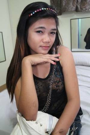 Young Filipina girl with a saucy look stands naked after undressing on fanspics.com