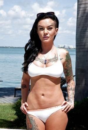 Tattooed whore Lolo Luscious exposing big hooters in swimming pool on fanspics.com