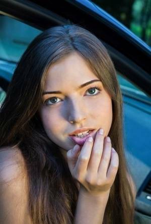 Beautiful teen girl models in the nude on passenger seat of car with door open on fanspics.com