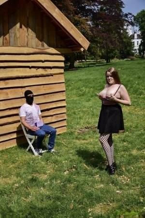 Natural redhead masturbates on a lawn before teasing a masked man on fanspics.com