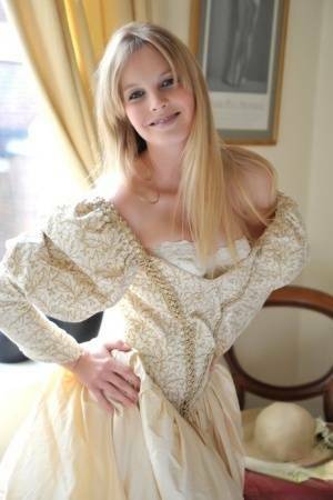 Blonde girl Rose takes off her petticoat to model in a girdle and nylons on fanspics.com